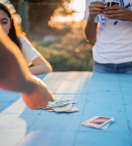 woman in white tank top and blue denim shorts standing near white smartphone on table