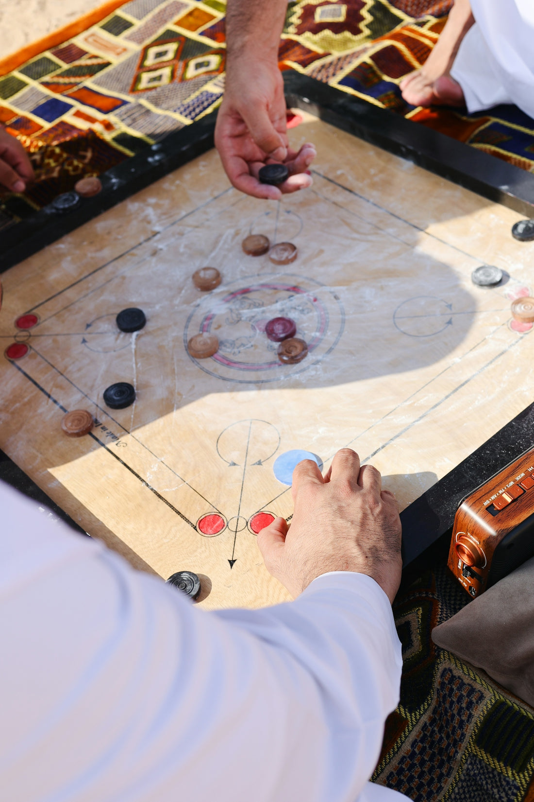 A group of people playing a game of carrom