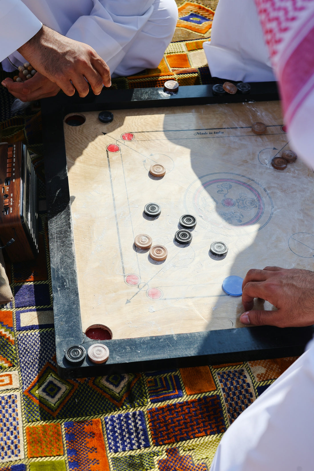 A group of people playing a game of carrom