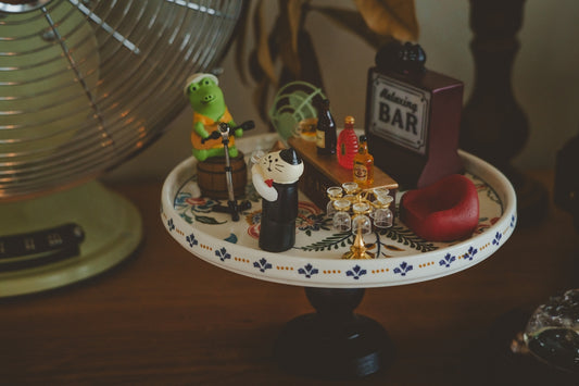 A table topped with a cake plate covered in figurines